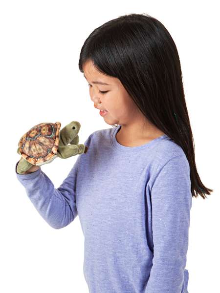 Barn leger med fingerbamse landskildpadde på fingeren – stimulerer fantasi og sanser

