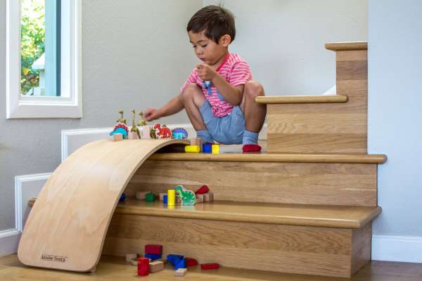 dreng leger med Kinderfeet Kinderboard natural, der ligger på trappe