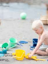 Børn leger på stranden med produkter fra scrunch.