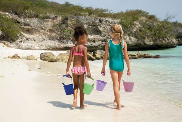 Piger går på stranden med scrunch buckets i forskellige farver