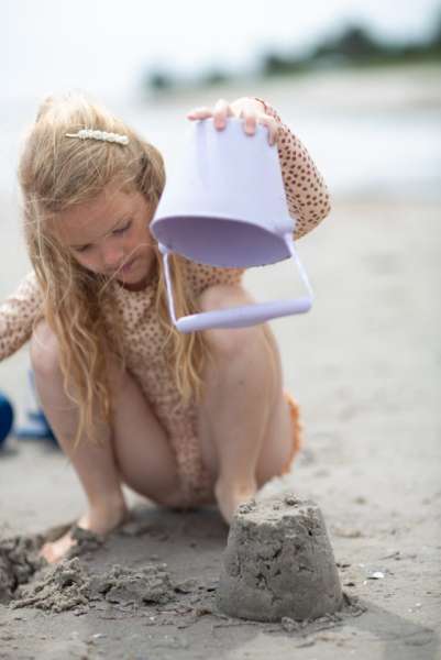 Pige leger med Scrunch bucket i pastel lilla.