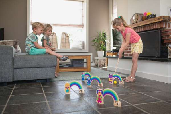 Børn spiller regnbue kroket inde i en stue
