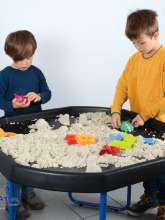 Børn leger med sansesand ved legebord