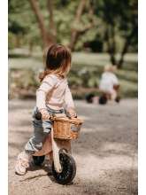 Pige på Kinderfeets Tiny Tots plus rose 2-i-1 cykel vist som løbecykel