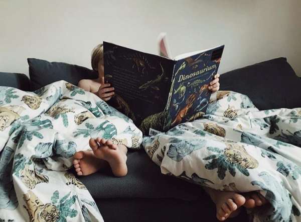 Børn læser i  bogen Dinosaurium fra forlaget Mammut