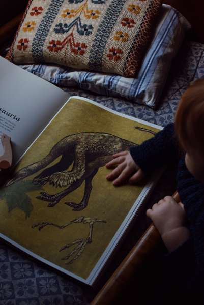 Børn læser i  bogen Dinosaurium fra forlaget Mammut