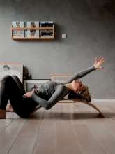 Kvinde bruger Kinderfeets Kinderboard Large, natural til yoga og udspænding
