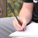 Person skriver med Ark's Write-n-Bite bidetop med kuglepen