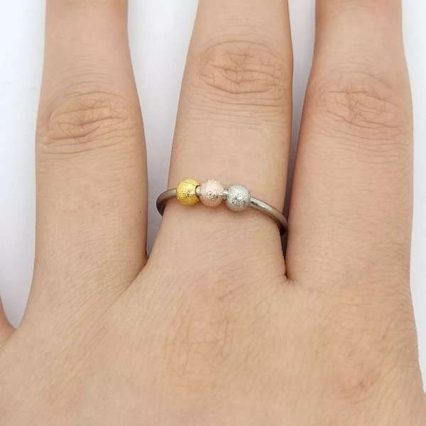 Anxiety ring i guldfarve på finger – diskret fidget med farvede perler

