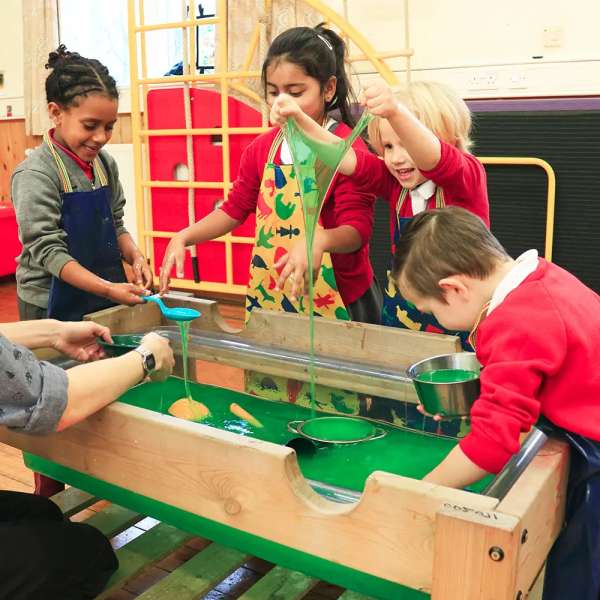 Børn leger med slim ved sansebord i institution med Zimpli produkter

