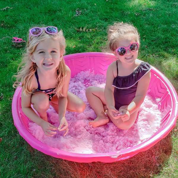 to piger bader i Glitter gelli baff pink i pink balje ude på græsplænen