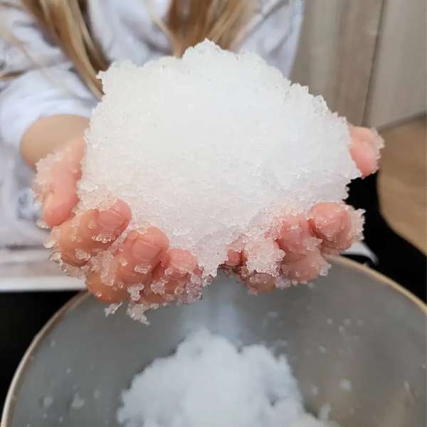 Hænder holder realistisk kunstig sne lavet med Zimpli SnoBall Play

