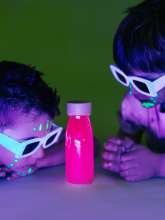 2 børn kigger på Petit boum float fluo pink sanseflaske i uv-lys