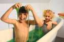 2 børn leger i badekar med grønt Zimpli Kids Slime baff
