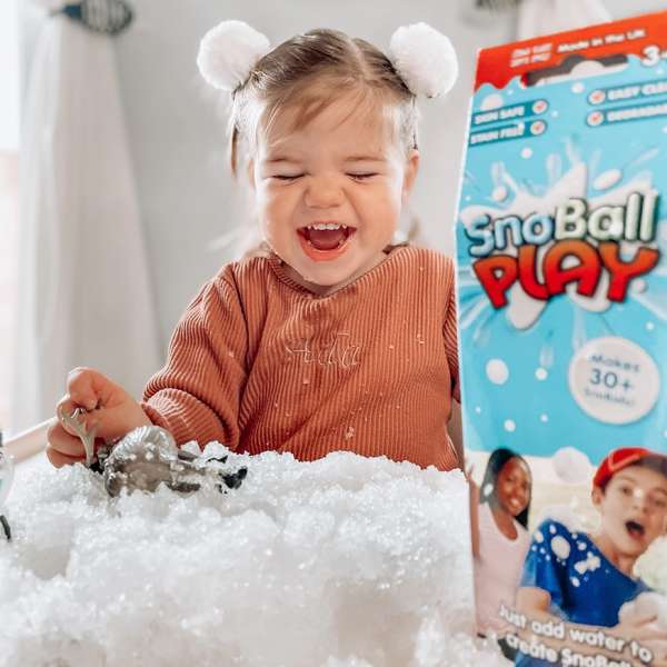 Smilende barn leger med kunstig sne og ske fra SnoBall Play

