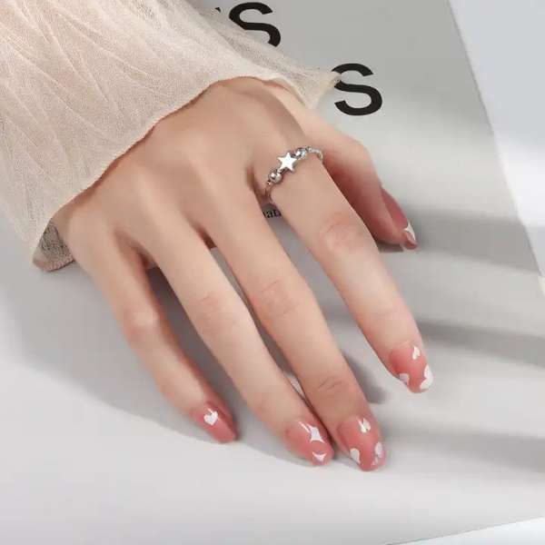  Anxiety ring med stjerne og perler på finger – diskret og elegant fidget

