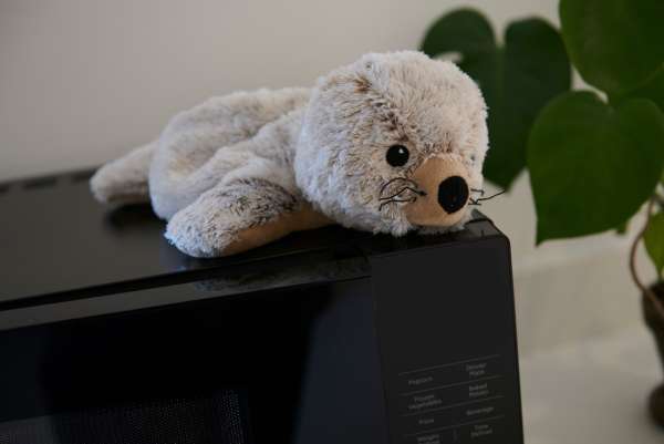 Sansebamse Warmies sæl på møbel – tyngdebamse til børn med behov for ro og sanselig støtte


