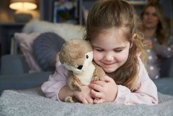 Barn krammer Sansebamse Warmies odder – blød og beroligende bamse til sanselig regulering og tryghed


