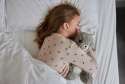 Sansebamse Warmies Egern ligger og sover samme men en pige i en seng 