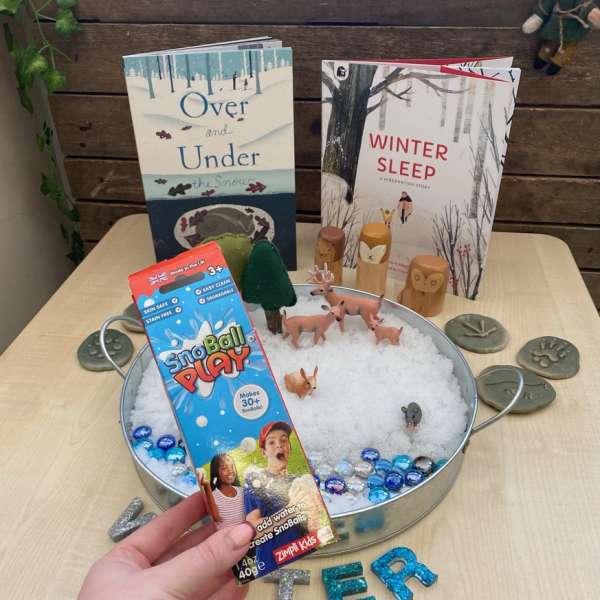 Kreativ vinterleg med SnoBall Play kunstig sne og legetøj på bord

