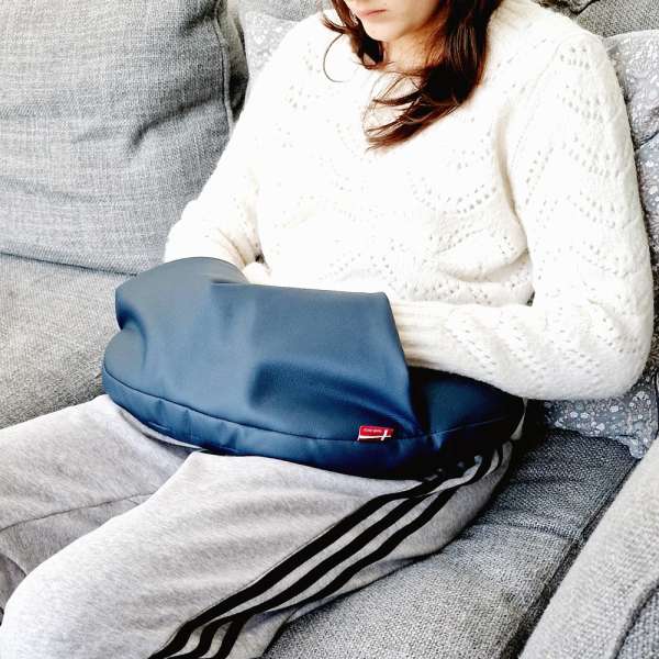 Person bruger sansemotorisk lårpude Maya Lille på sofa – afslappende og tryghedsskabende støtte

