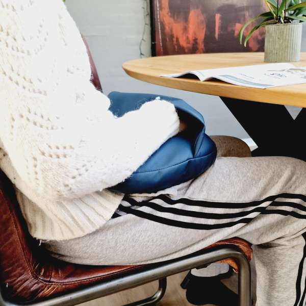 Sansemotorisk lårpude Maya Lille placeret på skød for beroligende tyngde og kropsfornemmelse