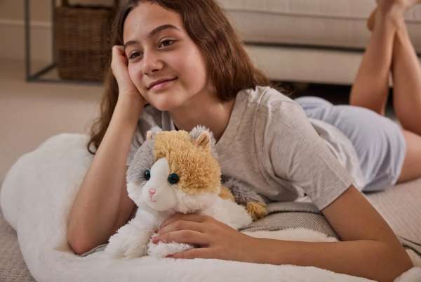 Sansebamse Warmies Calico Kat sammen med en pige