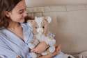 Sansebamse Warmies siddende ged sidde i en sofa sammen med en pige