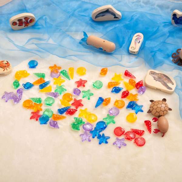 Transparente strandskaller i sand – sanselig udforskning og kreativ leg

