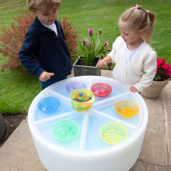 Børn leger med transparente sorteringsskåle – sanselig leg med lys og farver

