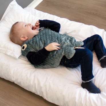 Koko Nora Vægttæppe Lille Manta vist hængende på væg med synlige teksturer og bløde materialer