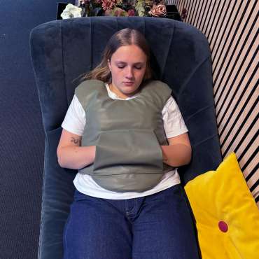 Trygge Max – person bruger tyngdevest i stol for ro og komfort

