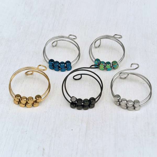 Fidgetring med firkantede perler vist samlet på flade, hvor perlernes farver og form tydeligt ses