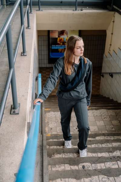 en pige gå op af en trappe og hun har en CalmDesign bæltetaske med tyngde over skulden 