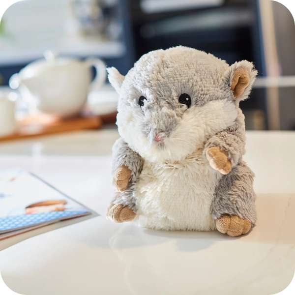 Sansebamse Warmies Grå Hamster sider på et bord 