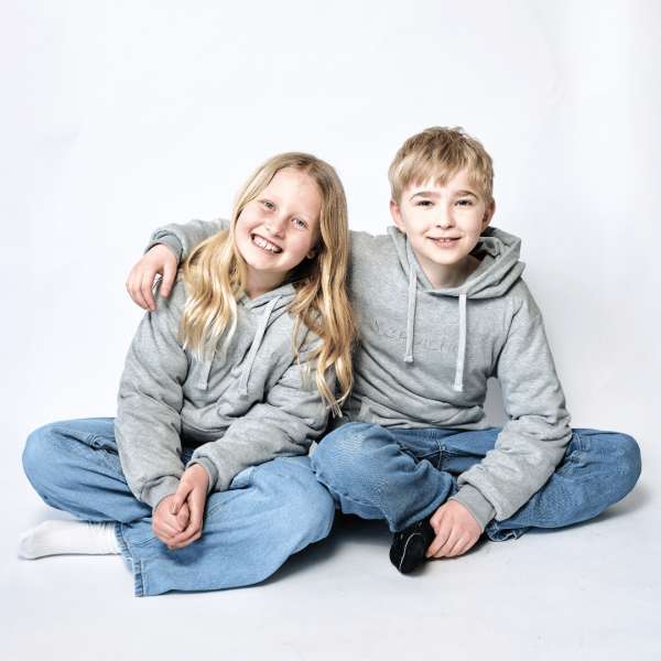 To børn i grå tyngdehoodies sidder sammen, komfortable hoodies til børn med fokus på ro og tryghed

