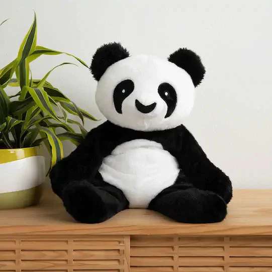 Pandaen Bowie sider en reol samme med en grøn plante 