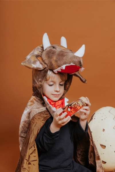 Barn i dinosaurkostume bruger Sanseflaske Move T-Rex – stimulerer fokus og ro

