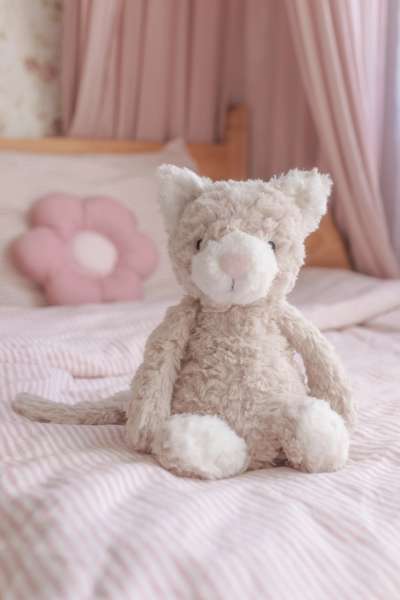 Katten Pickles bamse siddende på seng – blød og tryghedsskabende krammeven

