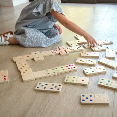 Barn leger med juvel-domino i træ – udvikling af finmotorik og koncentration


