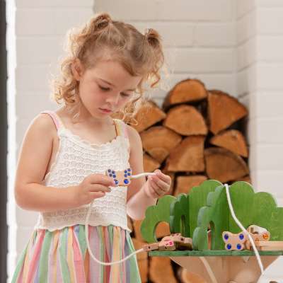 tickit® Sommerfugleperler i træ bliver leget med af en pige