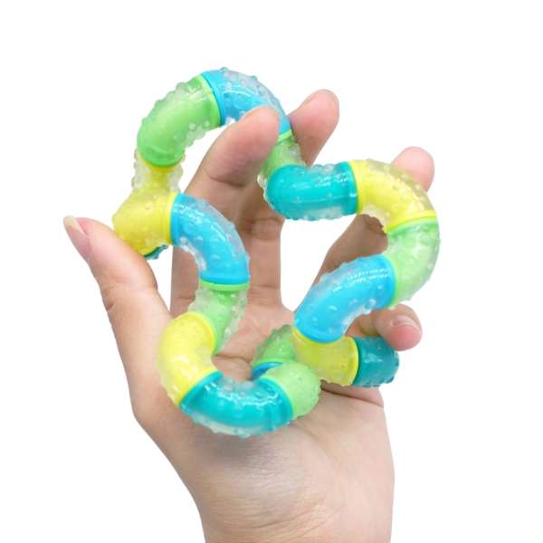 Hånd holder Tangle BrainTools Think – fidget til at dreje og manipulere for bedre koncentration og ro

