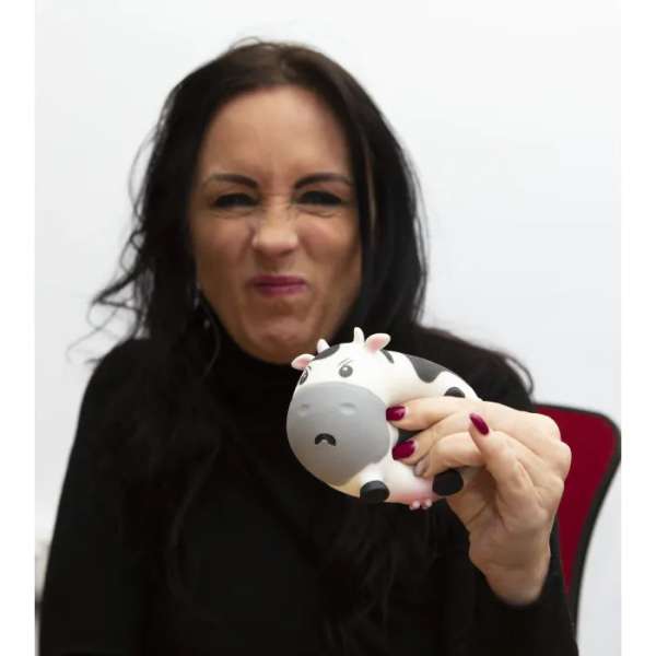 En kvinde holde en Mooody ko fidget – antistress klemmedyr frem imens hun giver den er klam