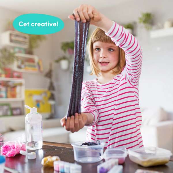 Barn strækker hjemmelavet slim ved bord med ingredienser – kreativt DIY slim legetøj



