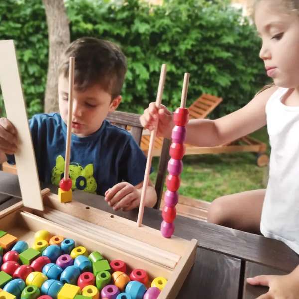 to børn er igen mad at lege med Sensorisk stablespil – træbrikker og tråde til motorisk og logisk leg.


