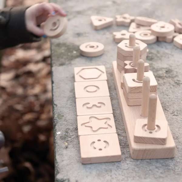 Taktilt stablespil med geometriformer – stimulerer følesans og finmotorik. står på et borg 

