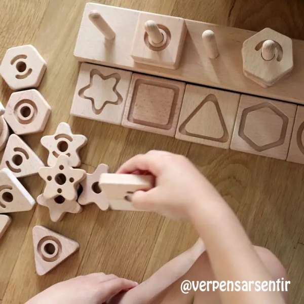 Børn bygger med sensoriske geometriformer – kreativ stabling og læring.