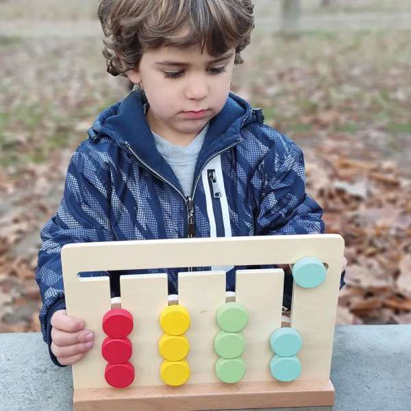 Dreng er igen med at lege med Andreu Toys farve- og formmatch – læringsspil til finmotorik og koncentration.

