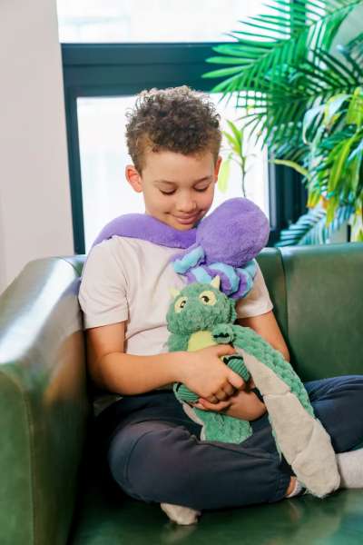 Barn sidder med Blæksprutten Indigo Hugaround – tyngdebamse til afslapning, fokus og kropslig regulering

