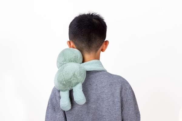 Dovendyr Little Hugger i grøn båret på ryggen – omsluttende tyngdebamse til sanselig støtte og nærvær

